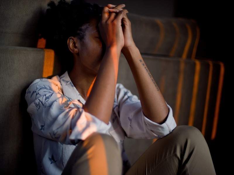 Mulher sentada no chão com depressão.
