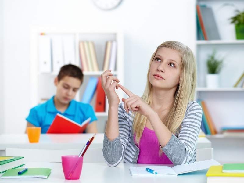 Menina contando nos dedos repetidas vezes.