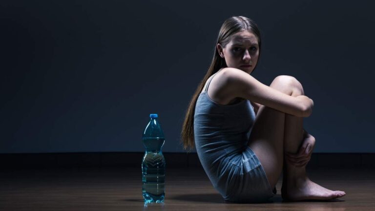 Mulher sentada em em sala isolada devido ao TOC.