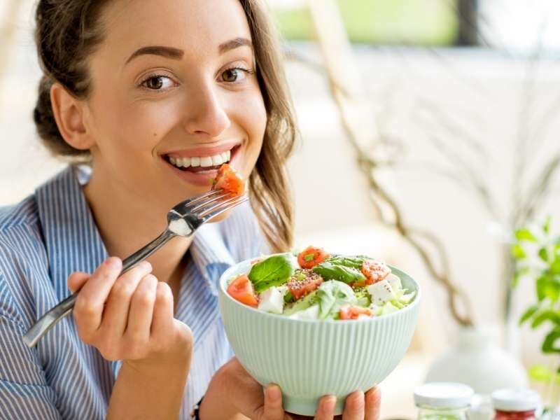 Mulher comendo alimentos saudáveis para prevenir o infarto.