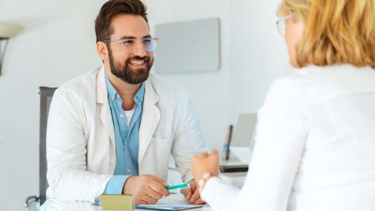 Médico sorrindo e paciente comemorando.