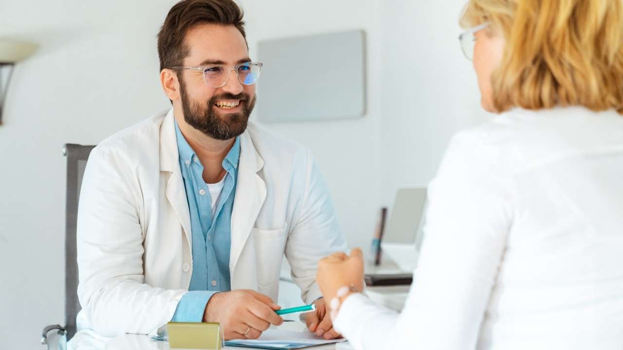 Médico sorrindo e paciente comemorando.
