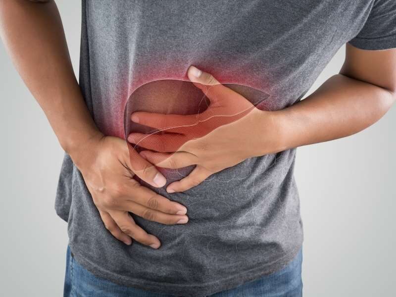 Homem com a mão na barriga.