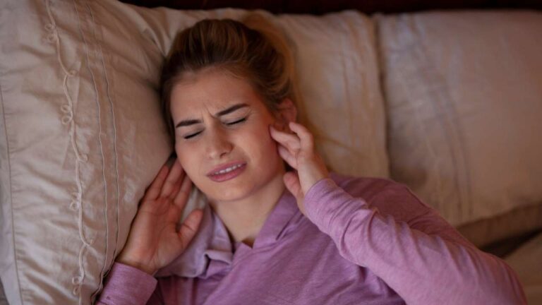 Mulher com dor na ATM articulação temporomandibular.