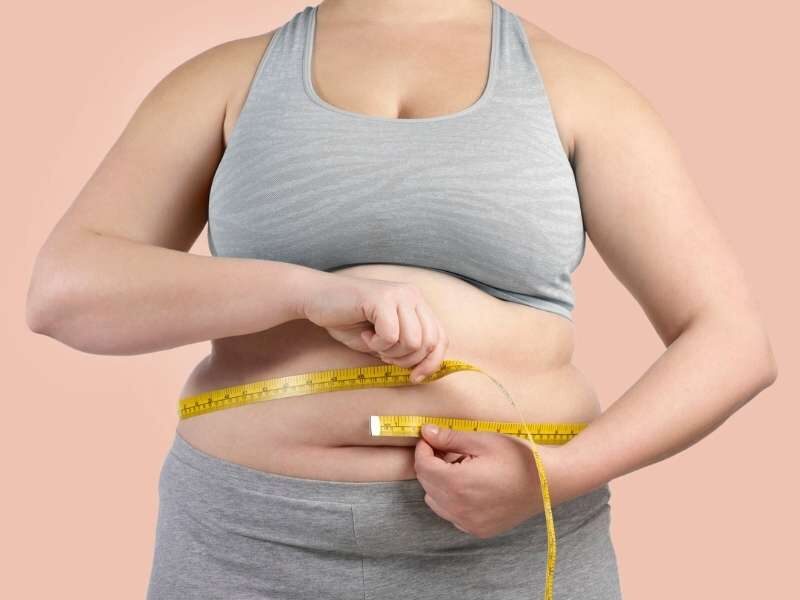 Mulher obesa medindo circunferência abdominal.