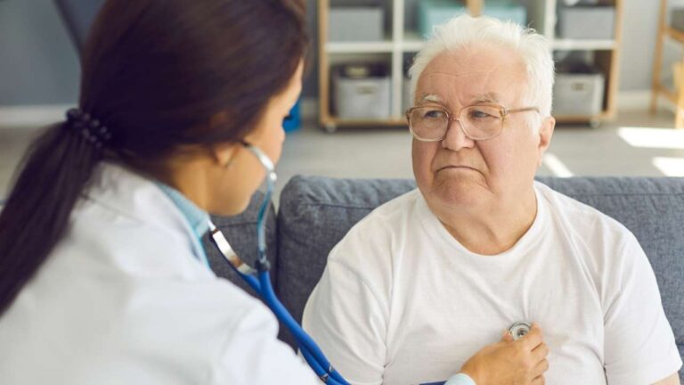 Cardiologista realizando exames em paciente idoso.