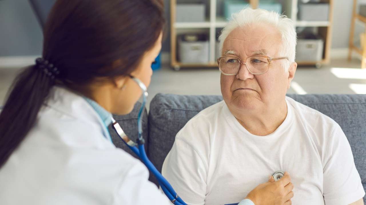 Cardiologista realizando exames em paciente idoso.