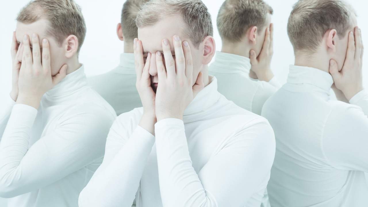 Homem com a mão no rosto com varias faces.
