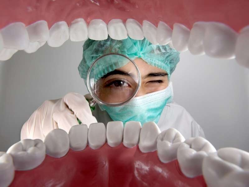 Dentista avaliando a boca do paciente.