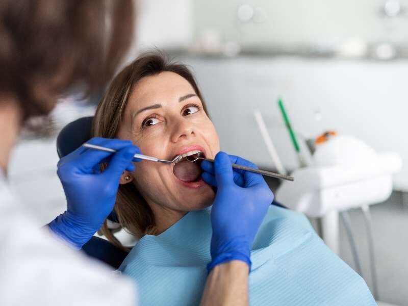 paciente sendo atendida por dentista.