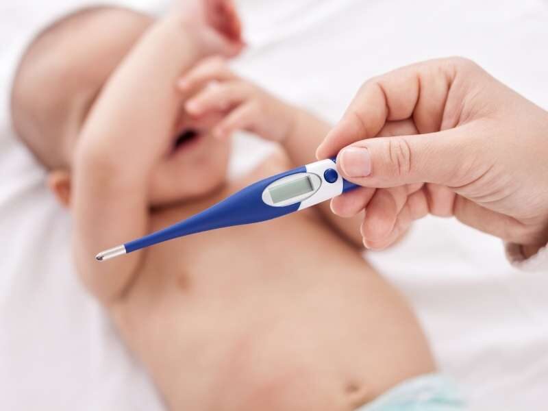 Mãe aferindo temperatura do bebê.