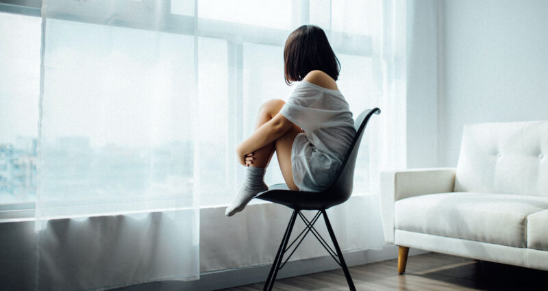 menina sentada sozinha com desequilibrio hormonal feminino