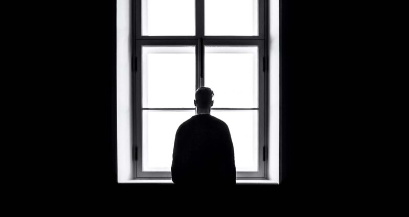 homem solitario na frente da janela