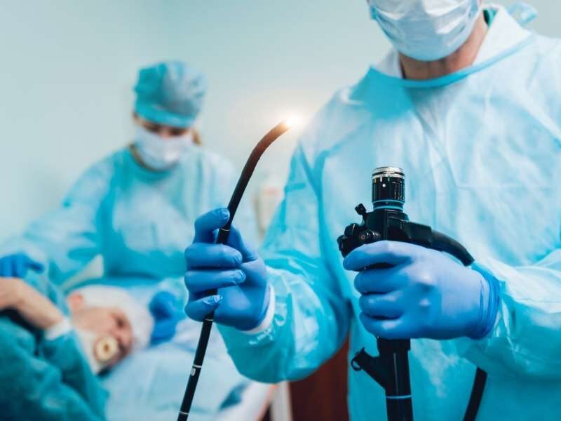 Médico preparando instrumentos para colonoscopia.