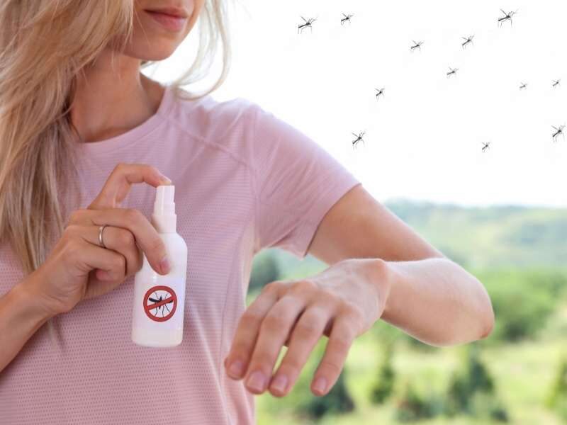 Passando repelente para afastar mosquito da dengue.
