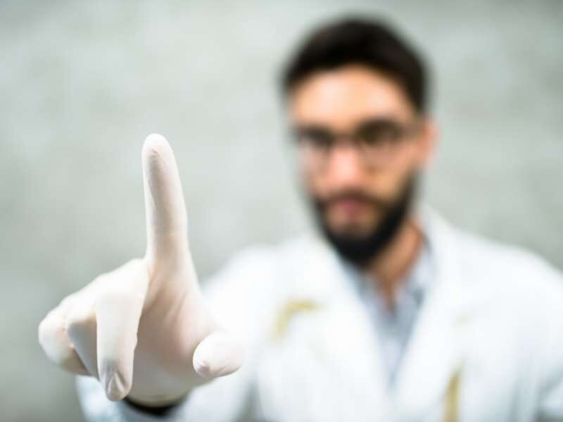 Médico urologista se preparando para fazer exame de toque.